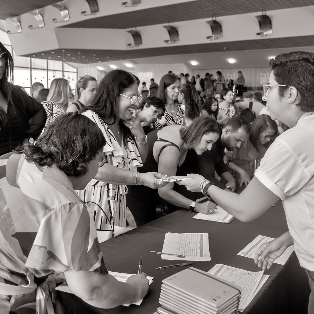 [Imagem de Networking]: Participantes interagindo no credenciamento e áreas comuns de congresso.